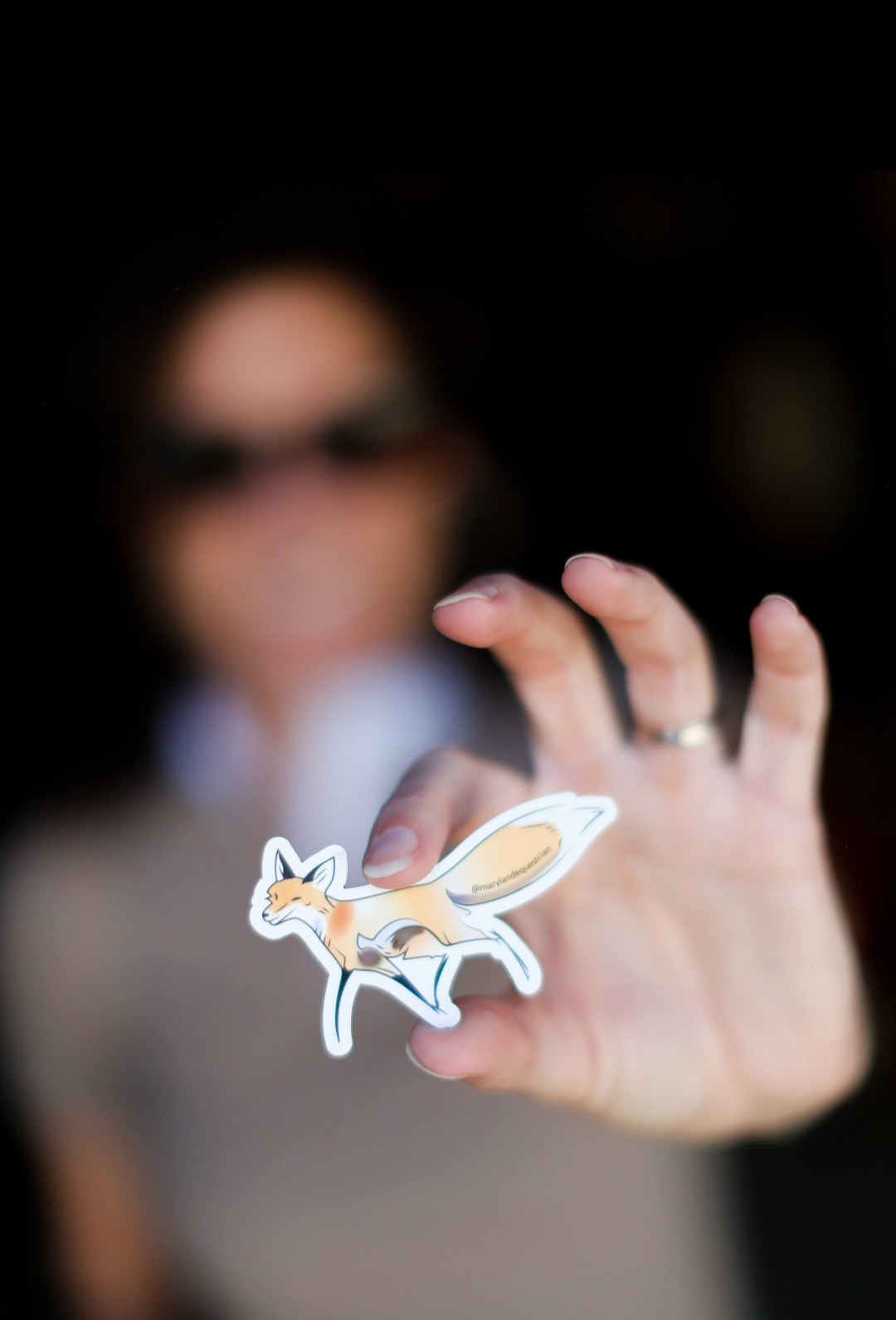Laurie Berglie holding two Maryland Equestrian fox stickers